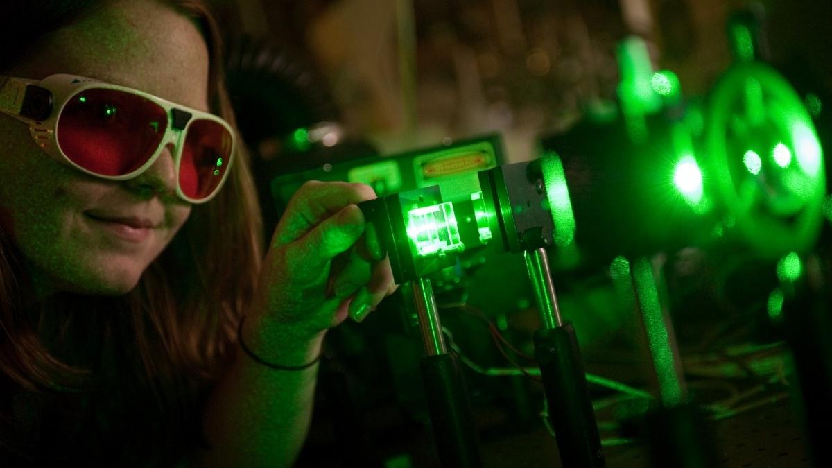 Student with protective glass in photonics lab