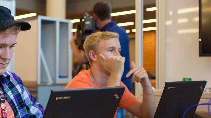 two students work on their laptops 